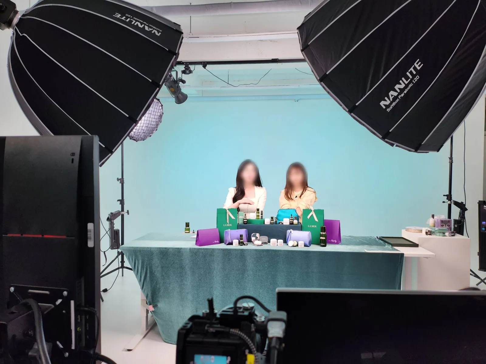 민트색 배경과 대형 소프트박스 사이에서 진행되는 뷰티 라이브 세트